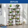 A multi-tiered plant stand filled with various potted plants, displayed indoors against a white wall with natural light filtering through a sheer curtain. Podgląd zdjęcia produktu