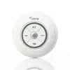 A white, circular Bluetooth speaker with control buttons and a brand logo, presented on a white background with a reflection. Voir les images du produit