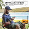 A man sits in a camping chair by a lake, using his phone, with a portable radio on a table next to him. Produktbild-Vorschau