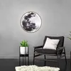 A modern living room with a moon-shaped wall lamp, a chair, and a plant. Náhled obrázku produktu
