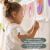 A young girl is playing with a tent, interacting with its features. Náhled obrázku produktu