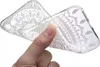 A hand is holding a clear phone case with a white henna-like pattern. Produktbild-Vorschau