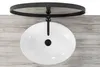 A white oval basin sink with a black faucet and drain, mounted on a wooden surface. Náhled obrázku produktu