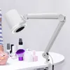 A nail dust collector with LED light is shown on a table with nail polish bottles and a brush. Podgląd zdjęcia produktu