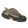 A single brown hiking shoe with blue ice cleats attached to the sole, shown from a side angle against a white background. Anteprima dell’immagine prodotto