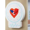 A close-up of a toy doctor's office clock with a heart design. Anteprima dell’immagine prodotto