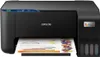 A black Epson EcoTank L3231 printer is shown from the front, with a sheet of paper partially printed with charts and colorful letters emerging from the paper tray. Voir les images du produit