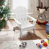 A white Adirondack chair for children is placed next to a decorated Christmas tree and a stuffed reindeer, with toys on the floor in the foreground. Produktbild-Vorschau