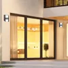 Exterior view of a modern house with large glass doors and wall lights. Produktbild-Vorschau