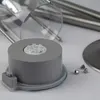 A close-up of a solar-powered LED light base with some small nuts in the foreground and metallic rods in the background. Produktbild-Vorschau