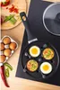 A frying pan with eggs and vegetables being cooked on a stovetop. Voir les images du produit