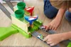 A child's hands are playing with a Hot Wheels Mariokart race track. Produktbild-Vorschau