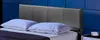 A bed with a dark gray headboard and two white pillows against a blue wall. Produktbild-Vorschau