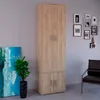 A tall, narrow cabinet with two upper doors and two lower doors, standing against a light gray wall with framed pictures and a painting on the side. Podgląd zdjęcia produktu