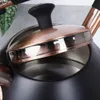 Close-up view of the lid of a black kettle with copper accents. Náhled obrázku produktu