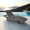 A grey rattan sun lounger is placed on a white deck next to an infinity pool with a scenic mountain and ocean view. Voir les images du produit