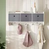 A wall-mounted shelf with storage bins and hooks, displaying accessories like hats, bags, and a coat. Voir les images du produit
