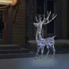 A lighted reindeer decoration stands on a snowy lawn in front of a house at night. Produktbild-Vorschau