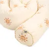 A close-up view of a cream-colored bolster pillow with a pattern of smiling suns. Produktbild-Vorschau