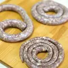 Three coils of raw sausage are arranged on a wooden cutting board. Produktbild-Vorschau