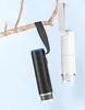 Two digital microscopes, one black and one white, are hanging from a tree branch against a light blue background. Produktbild-Vorschau
