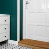 A corner of a room with a white dresser, a green wall, a white door, and a wooden step. Anteprima dell’immagine prodotto