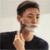 A man is shaving his face with a razor. Produktbild-Vorschau