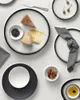 A top-down view of a table setting with plates, cheese, olives, and oil. Anteprima dell’immagine prodotto