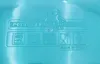 A close-up of embossed text and icons on a light blue plastic surface. Produktbild-Vorschau
