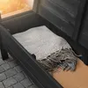 A close-up view of the open storage compartment of a dark wooden garden bench, with a gray blanket inside. Anteprima dell’immagine prodotto