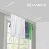A ceiling-mounted clothes drying rack with towels and a shirt hanging on it, positioned in front of a window. Anteprima dell’immagine prodotto