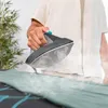 A person is ironing a garment on an ironing board, with steam coming from the iron. Náhled obrázku produktu