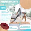 A woman performing a yoga pose on a cork yoga mat in a bright, modern room. Produktbild-Vorschau