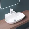 A white ceramic sink with a modern faucet is mounted on a wooden countertop against a teal wall. A backlit mirror is visible above the sink. Produktbild-Vorschau
