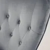 A close-up view of the tufted upholstery of a gray armchair. Náhľad obrázku produktu