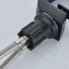 A close-up view of the connection point of a black faucet with two silver braided hoses attached. Podgląd zdjęcia produktu