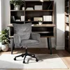A gray corduroy office chair in front of a wooden desk with shelves. Náhľad obrázku produktu