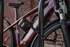 A close-up shot of a bicycle lock attached to a bicycle frame, parked at a bike rack. Náhled obrázku produktu