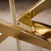 A close-up view of the metallic structure of a coffee table, highlighting its polished gold and chrome finishes and geometric design. Produktbild-Vorschau