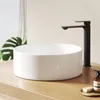 A modern bathroom sink with a black faucet on a wooden countertop. Produktbild-Vorschau
