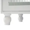 A close-up view of the bottom section of a white cabinet, showing its decorative legs. Produktbild-Vorschau