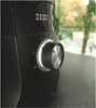 Close-up of a black kitchen appliance with a silver dial and a digital display showing '03:00'. The background is blurred and shows greenery and trees outside. Náhľad obrázku produktu