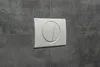 A white toilet flush plate with two buttons is mounted on a gray tiled wall. Náhled obrázku produktu