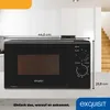 A black Exquisit microwave oven is shown on a countertop in a kitchen setting. Dimensions are indicated with lines and text. Produktbild-Vorschau