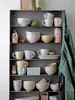 A collection of ceramic dishes and cups neatly arranged on shelves. Anteprima dell’immagine prodotto