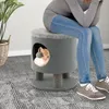 A person is sitting on a cat tree stool, with a cat peeking out of the opening. Náhľad obrázku produktu