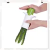 Hands using a vegetable slicer to cut a cucumber into long strips. Podgląd zdjęcia produktu