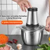 A person is operating a stainless steel food chopper in a kitchen setting, with ingredients like minced meat and chili peppers visible. Produktbild-Vorschau