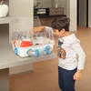 A young boy is looking at a hamster cage on a shelf. Produktbild-Vorschau