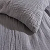 A close-up view of a grey textured fabric, likely a pillowcase or bedding. Produktbild-Vorschau